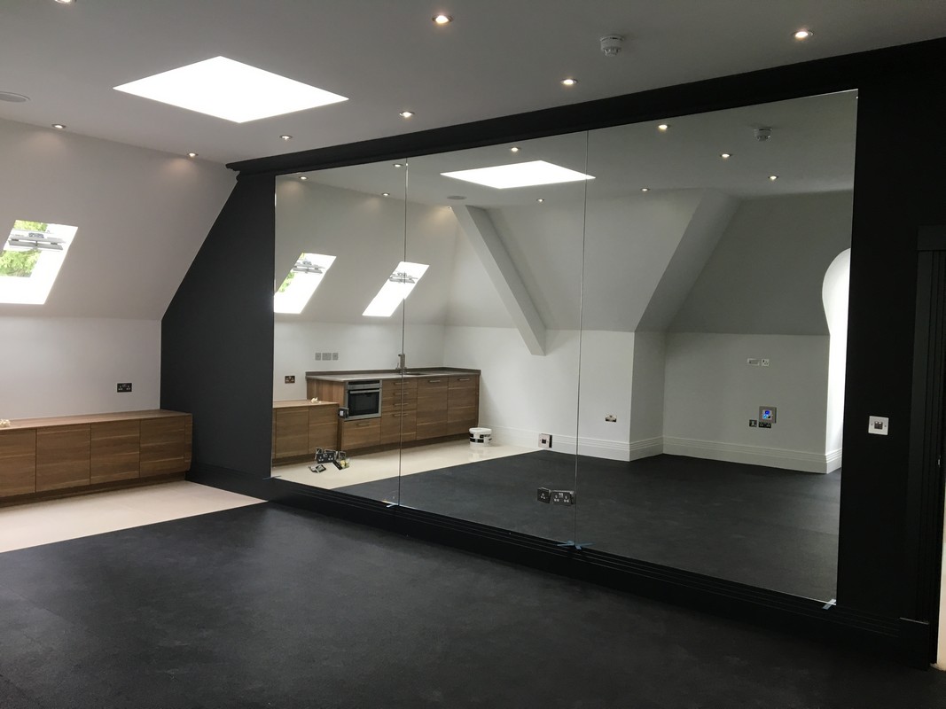Frameless glass wall dividing loft conversion in Notting Hill